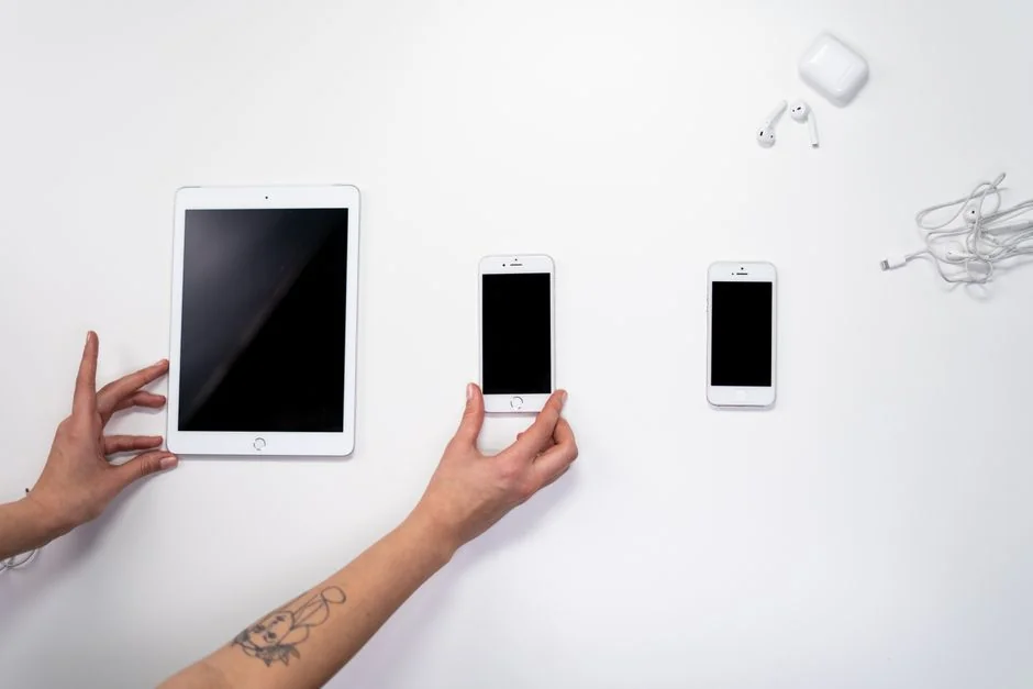 A sleek office desk setup featuring Apple devices: iMac, MacBook, and iPad.